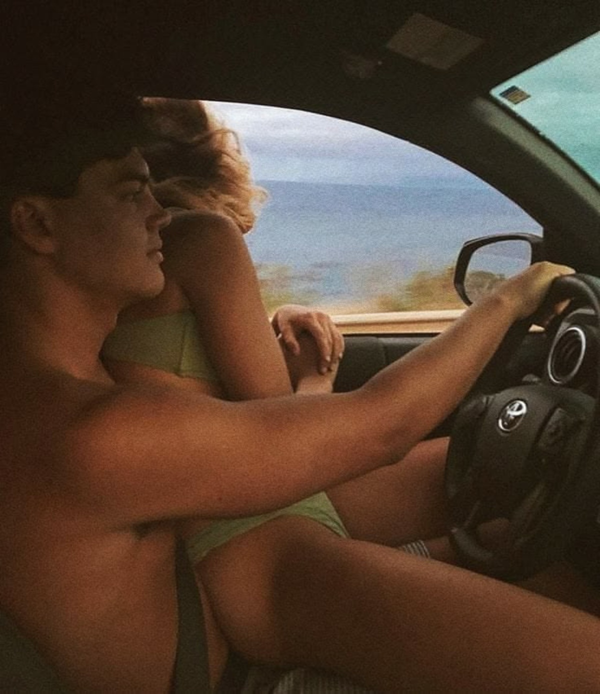Couple in a car by the ocean representing discreet private travel and anonymous connection