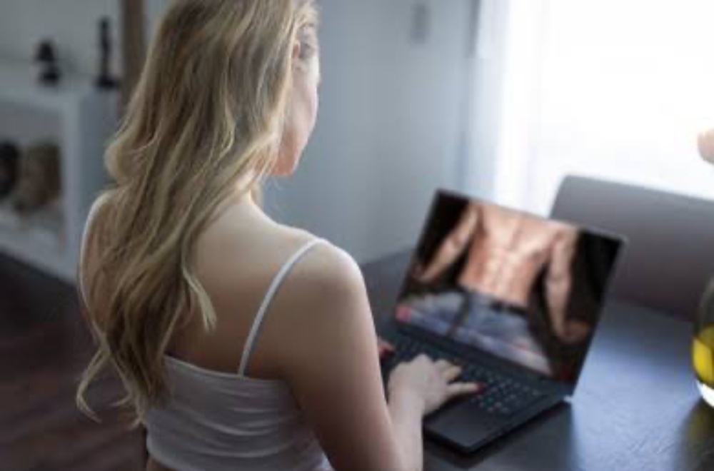 Woman on laptop enjoying private video flirty chat at home